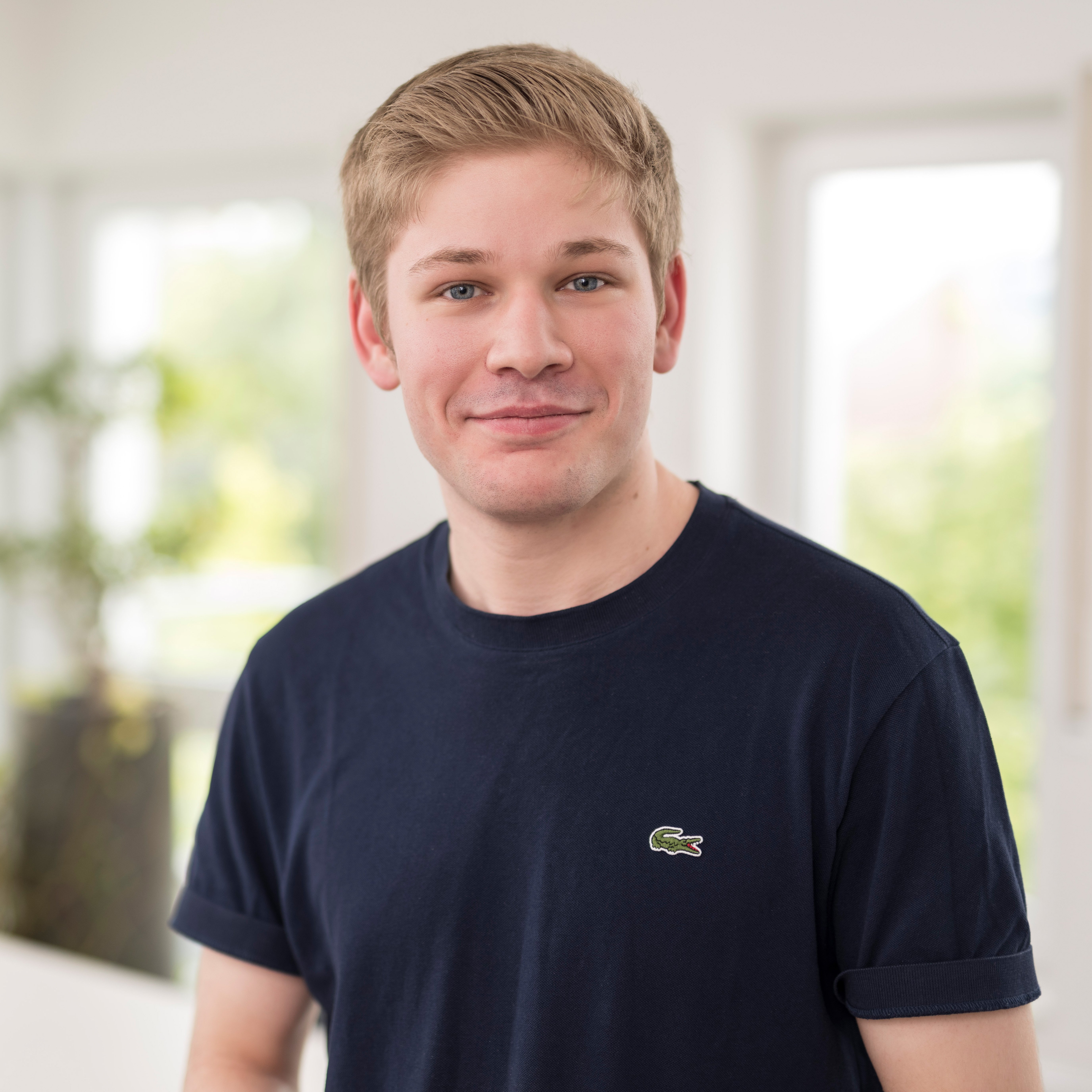 Medium close up of Lars Kölker in a navy blue t-shirt with crocodile patch from Lacoste